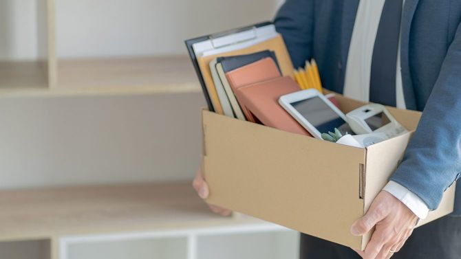 仕事を辞めるための箱詰めをするストレスフルなサラリーマン