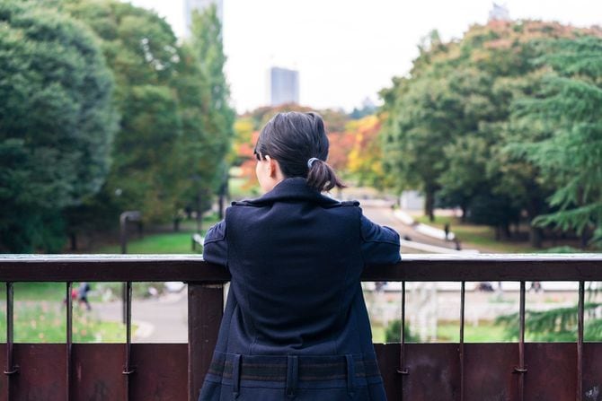歩道橋から景色を眺める女性