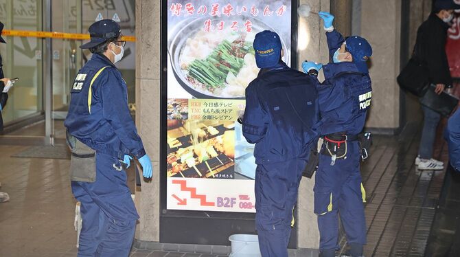 女性が襲われた現場付近で指紋などを採取する警察官＝2023年1月16日、福岡市博多区