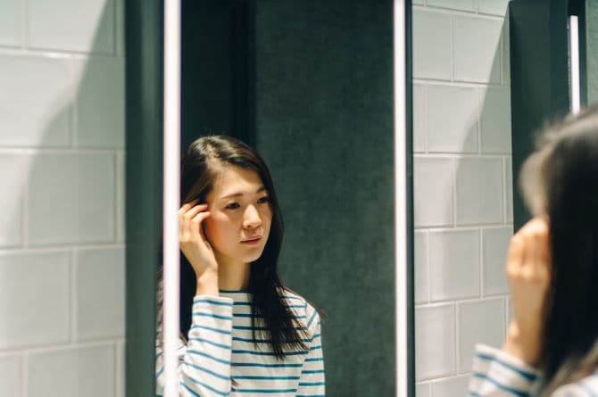 鏡の前に立つ女性