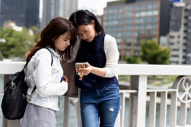 スマートフォンの画面を見る女性