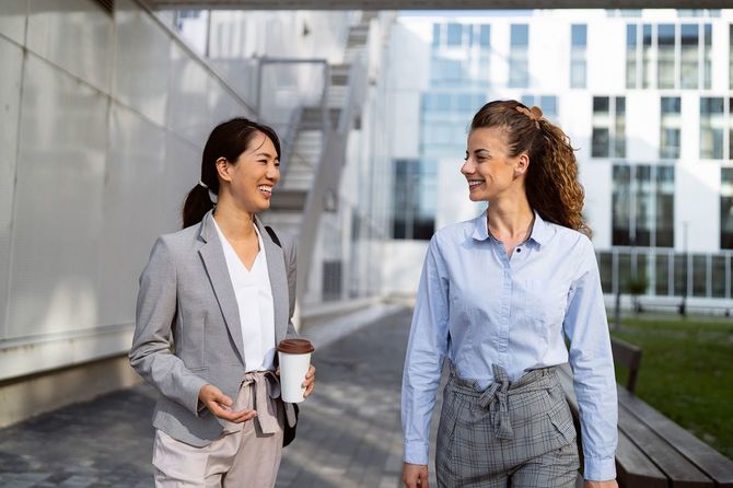 オフィスの外で会話をする2人のビジネスパーソン