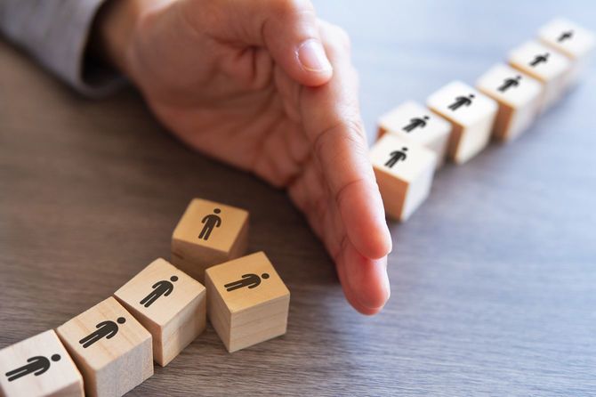 整列していた人が描かれた木製ブロックの途中に手を入れて、列を分断している