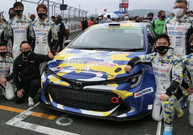 水素エンジン車と写真に納まるトヨタ自動車の豊田章男社長（前列左から2人目）＝2021年5月22日、静岡県小山町の富士スピードウェイ