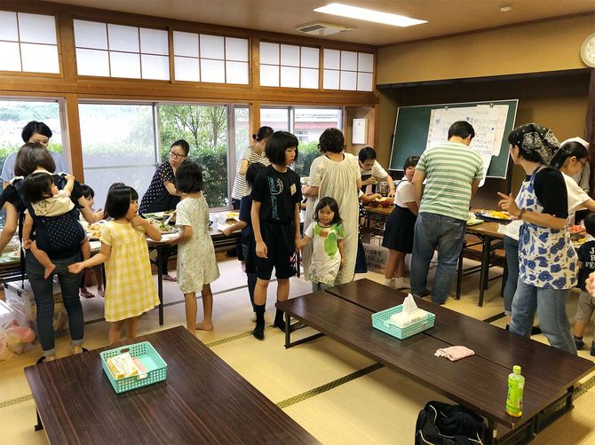 バイキング形式に並べられた食事を受け取っていく参加者たち。2019年に撮影。