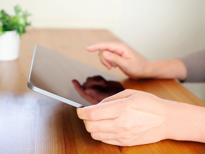 タブレット端末を使用する女性の手元
