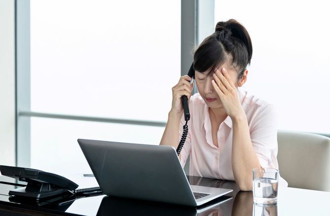 固定電話で話すストレスの多いビジネスウーマン