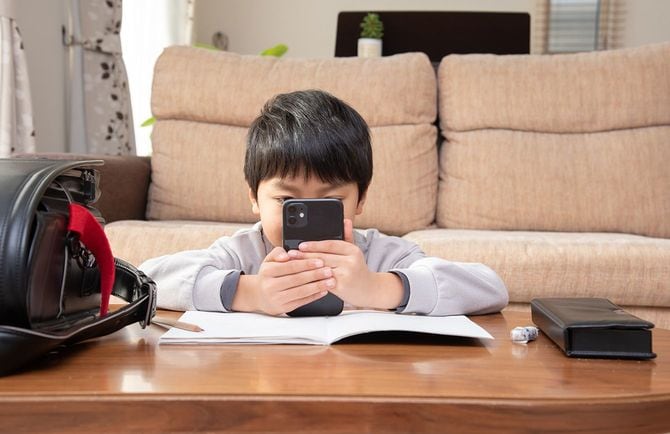 勉強中にスマホを見ている小学生の男の子