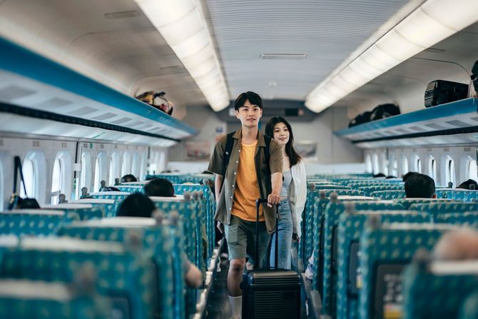 スーツケースを引きずりながら新幹線を歩く人たち