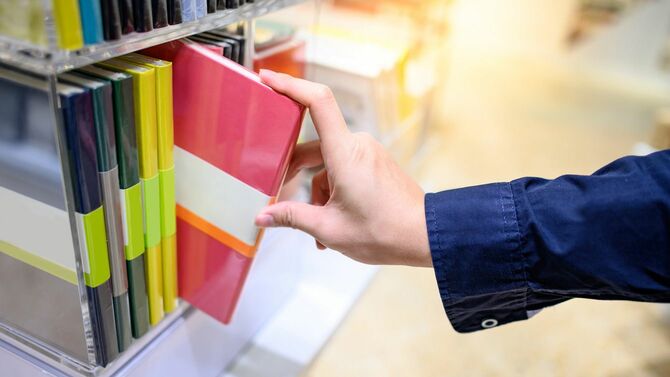 文房具店で手帳を選ぶ男性