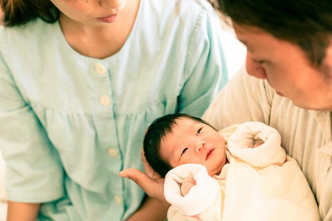病院で新生児をその手に抱く両親