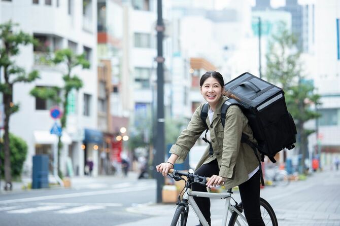 自転車で荷物を配達している若い女性
