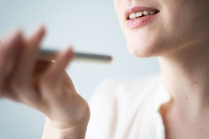 スマートフォンで音声入力をする女性