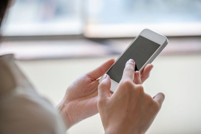 スマートフォンを操作する女性の手
