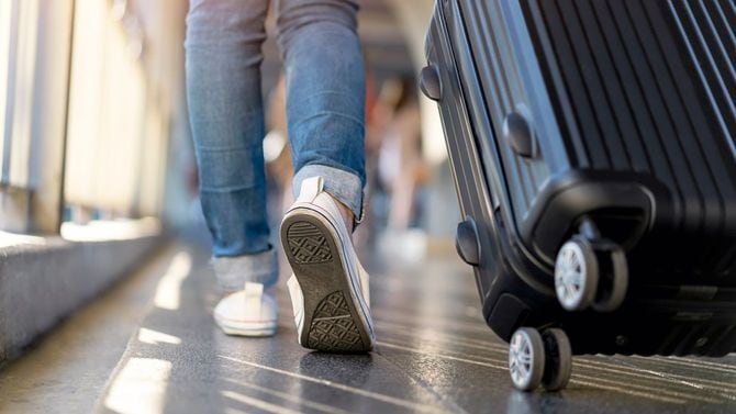 スーツケースをひいて一人で歩く女性旅行者