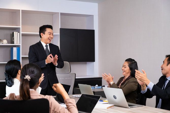 会議室で成功を喜ぶビジネスパーソンたち