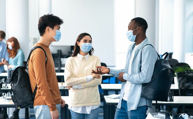 ヘルスケア、教育、ライフスタイル、人の概念。保護医療マスクを着用し、大学の講義室に立って、笑顔の多様な留学生のグループ