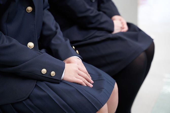 日本の中学生と両親が学校の廊下で待っている