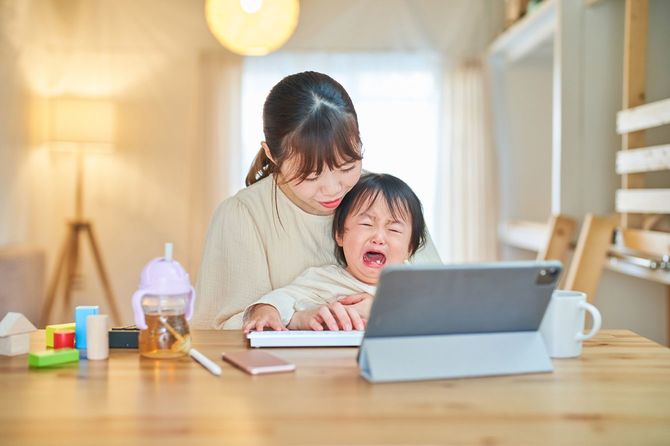 タブレットPCを操作する女性と幼児