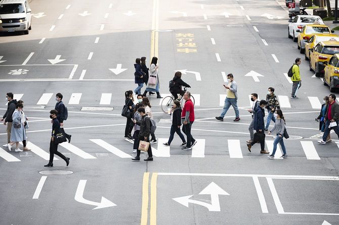 台湾の台北で、フェイスマスクを着用した人が交差点を横断している