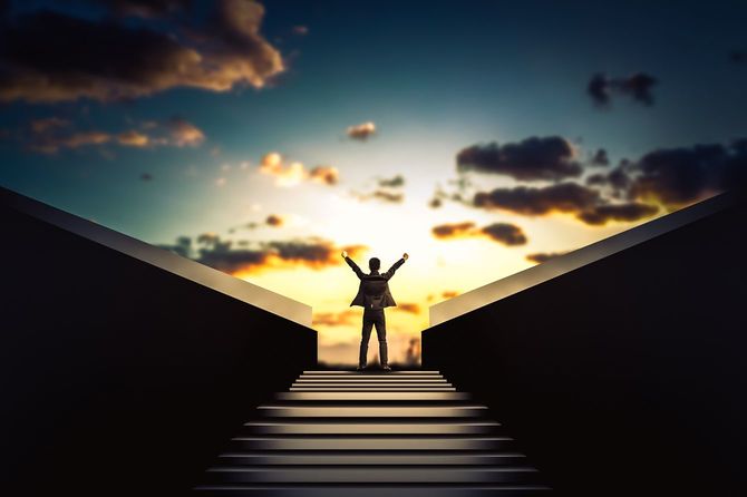 勝利の瞬間に腕を上げるビジネスマン