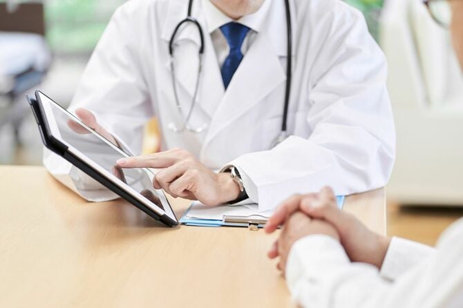 検査結果をタブレット端末を使用して説明する医師