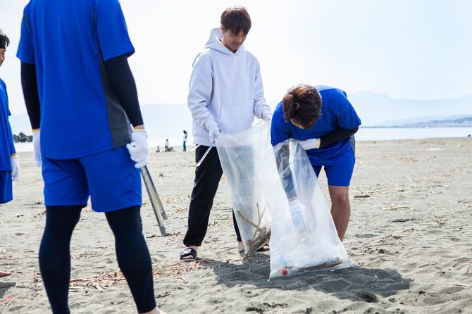 ビーチでゴミ拾いのボランティア活動をするチーム