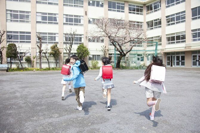 ランドセルを背負ってグラウンドを駆ける小学生