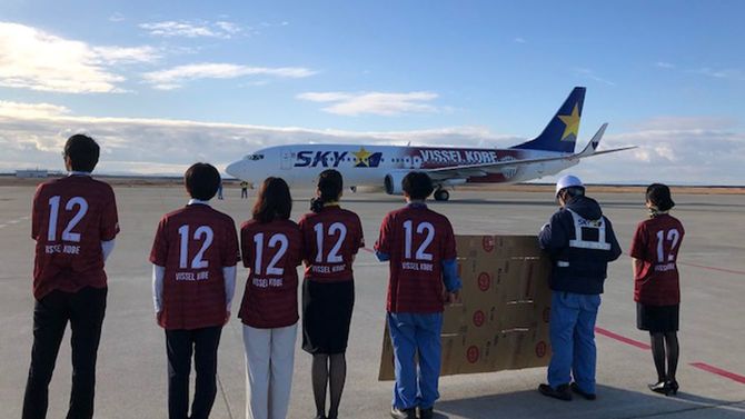 2020年1月1日、イレブンを応援する「12」の背番号のヴィッセルTシャツで5511便を見送る神戸空港支店の社員。