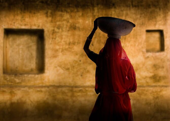 頭に物を載せて運ぶインドの女性