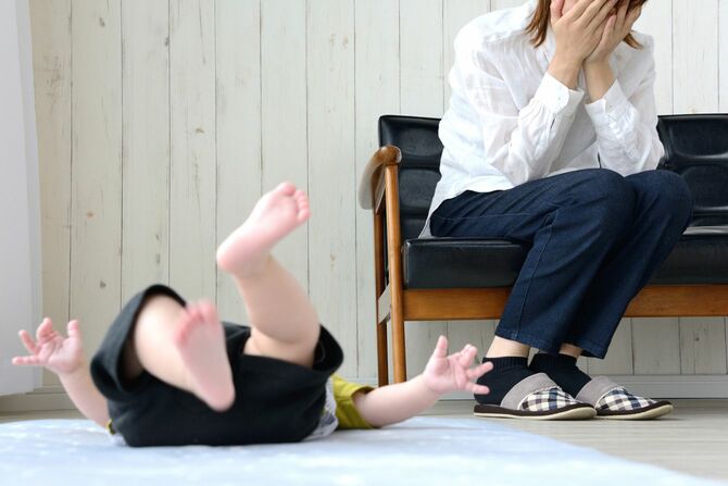 居間で疲れた母親と泣いている赤ちゃん