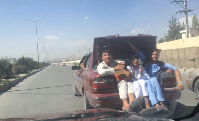 車のトランクに乗り込み音楽を楽しむ若者たち