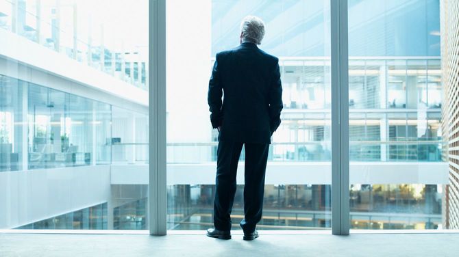 ビルの中庭を見つめるビジネスマン