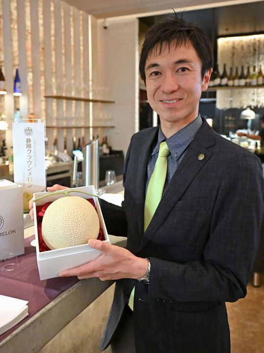 商談会で高級メロンの模型を手にする静岡県温室農業協同組合クラウンメロン支所の鈴木陽介経営戦略部長=2026年2月17日、オーストラリア・シドニー(共同)