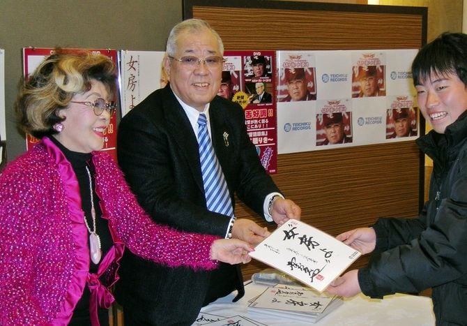 握手会でファンに色紙を渡す楽天の野村克也監督（中央）と沙知代夫人（左）