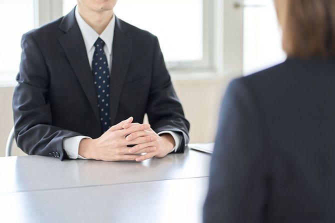 面接で机を挟んで向かい合う2人のビジネスパーソン