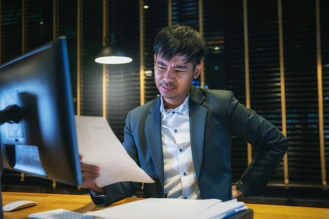 腰痛で腰をおさえるビジネスマン