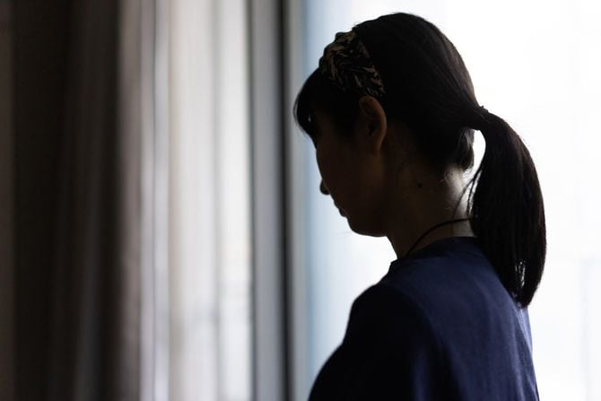 薄暗い部屋で俯く女性