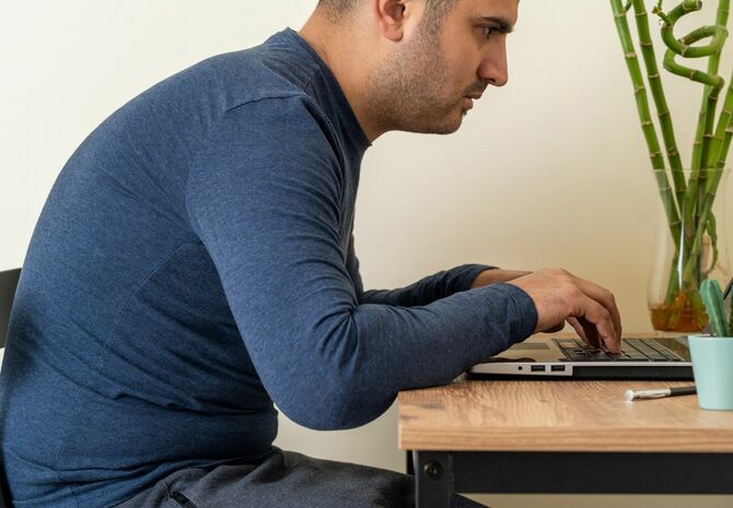 息を詰めてパソコン作業をしている男性