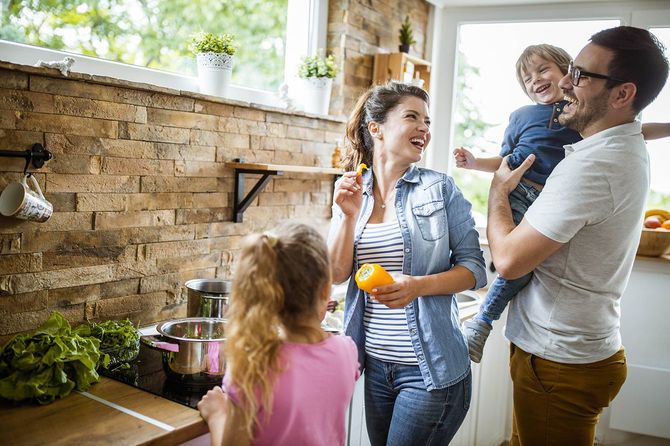 キッチンでランチを作りながら楽しんで幸せな家族