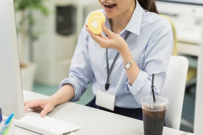 オフィスでケーキを食べる女性