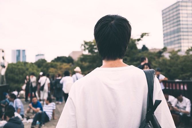 人々を眺める若者