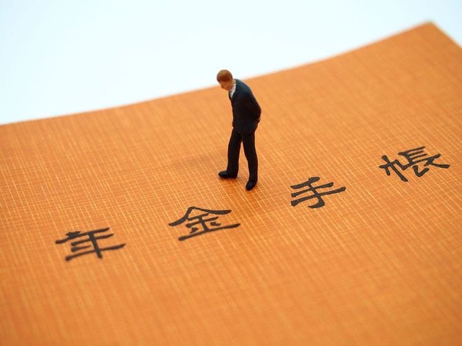 年金手帳とミニチュアの人形