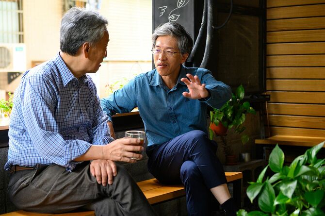 友人と話し合う高齢男性