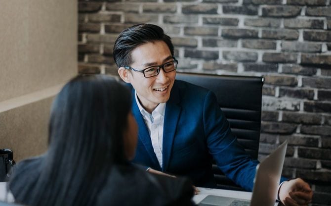 ノートパソコンをチェックする男女