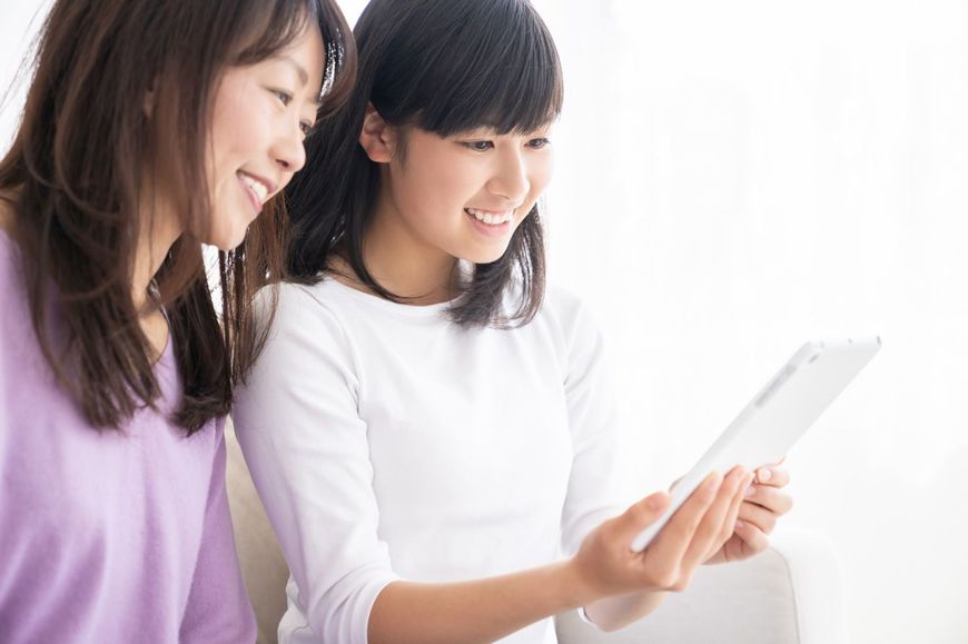 一緒にスマートフォンを見る母と娘