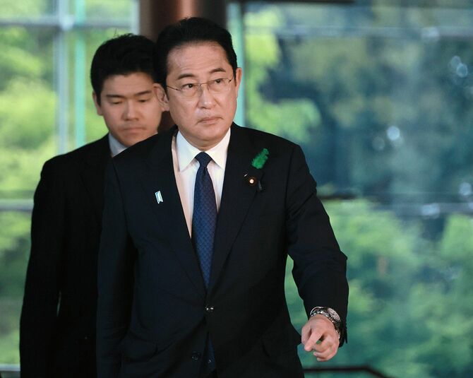 首相官邸を後にする岸田文雄首相（手前）。左奥は岸田翔太郎首相秘書官