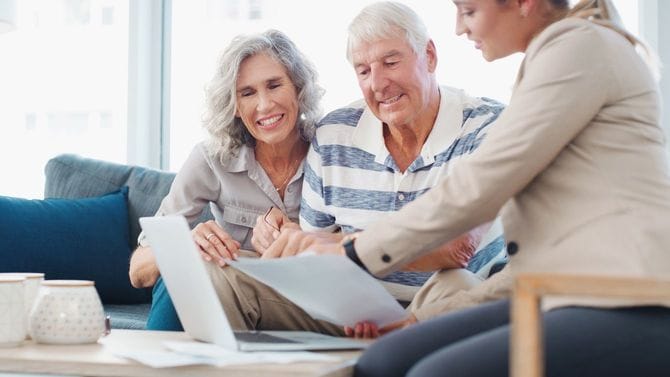 高齢夫婦がコンサルタントとともに書類を見てディスカッションしている