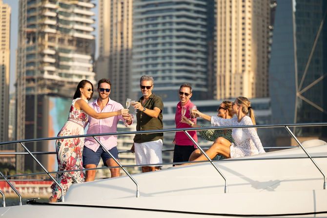 休暇中に豪華なヨットでシャンパンで乾杯する友人