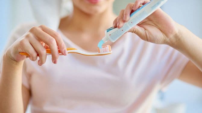 たっぷりの歯磨き粉を歯ブラシに乗せている女性